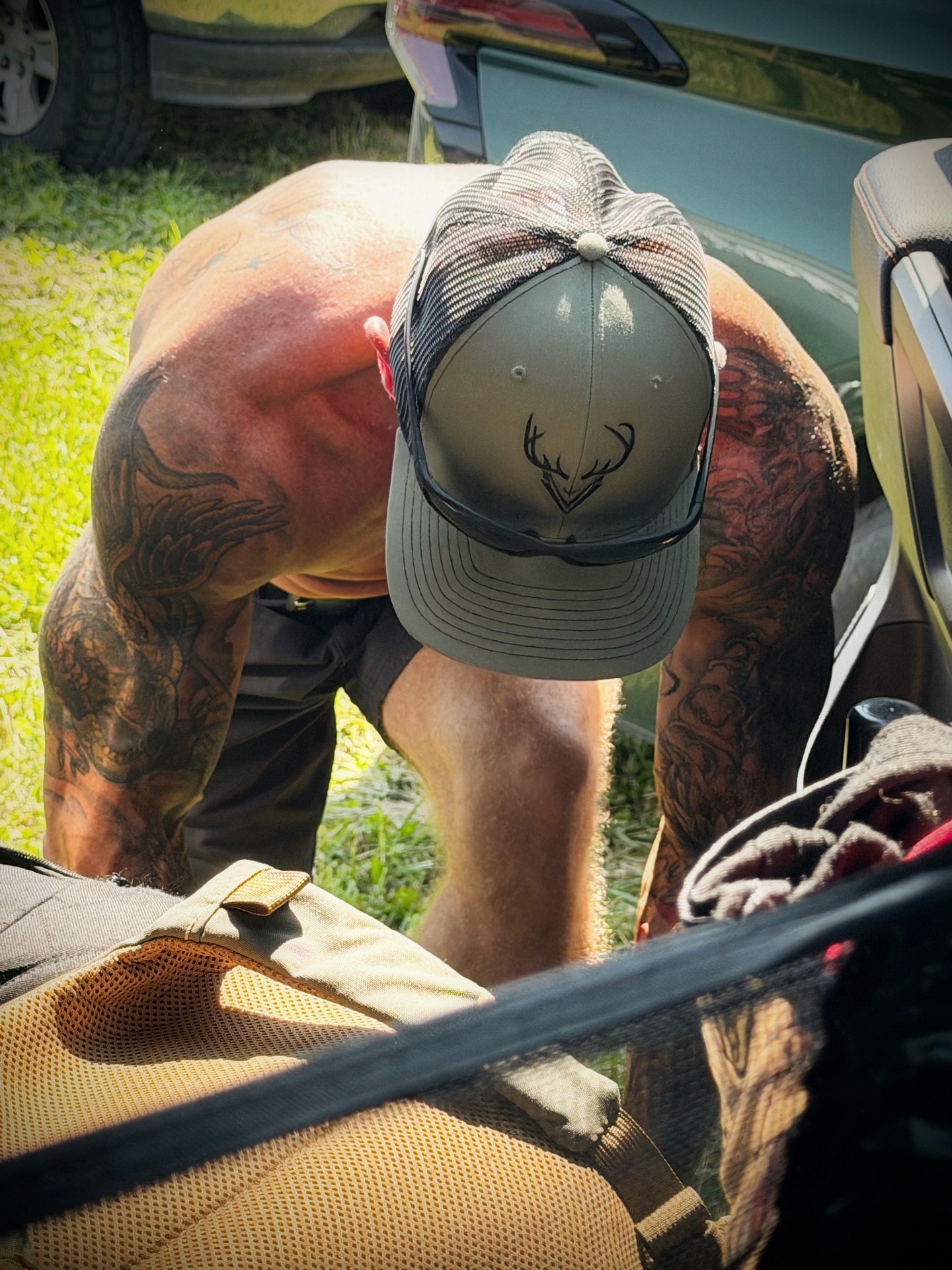 Anthony DelVecchio in a DelVecchio Outdoors cap loading gear at the truck