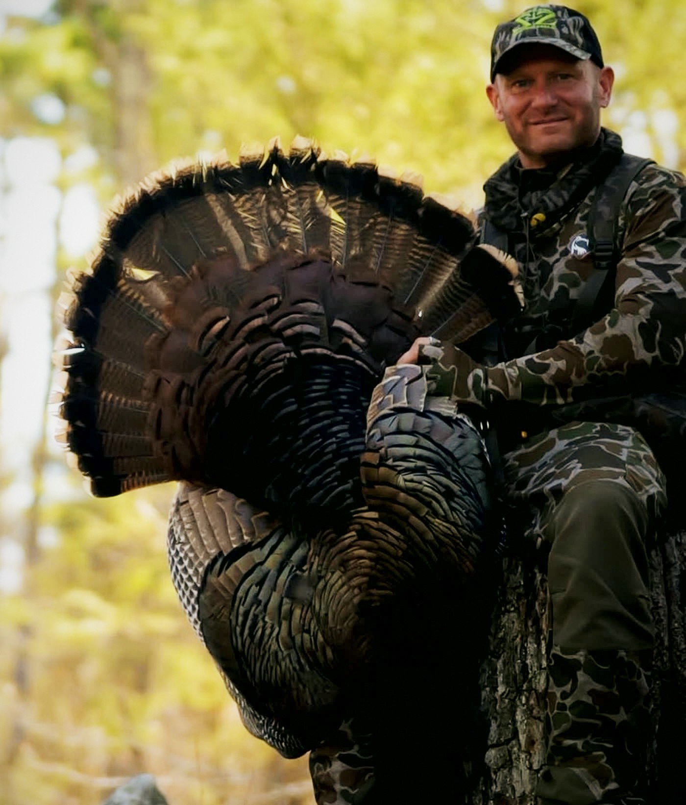 Hunter holding a heavy longbeard turkey with tail fanned out